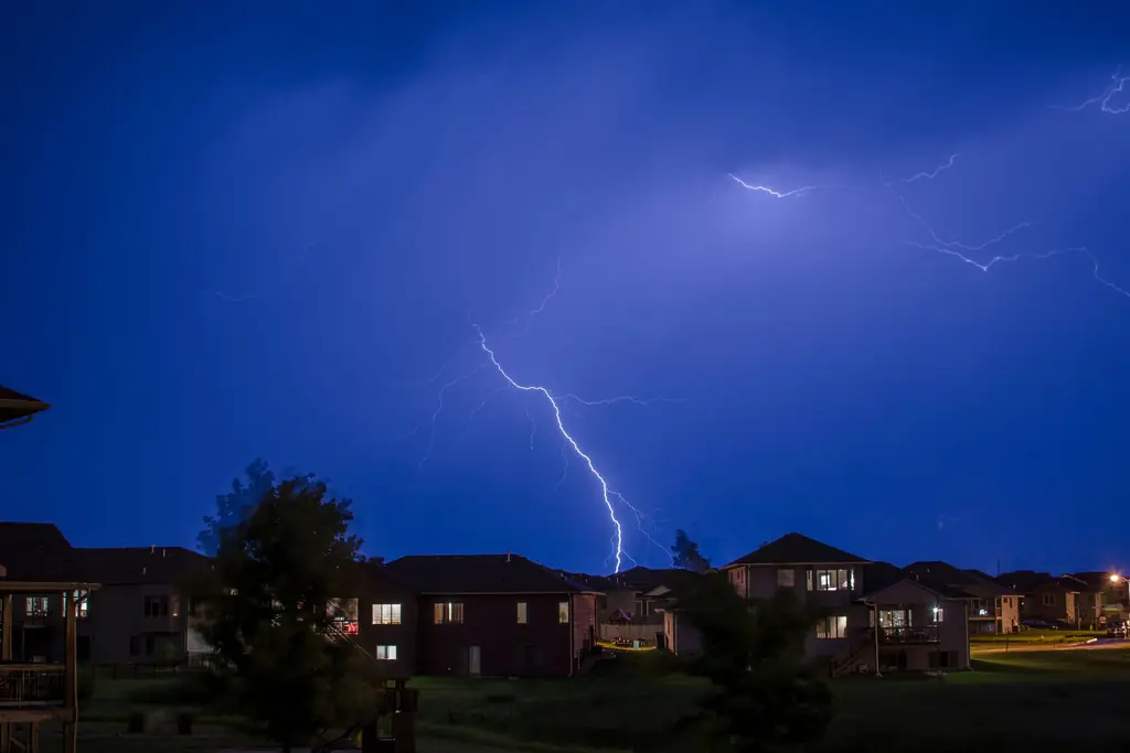 Lightning over a row of suburban houses at night